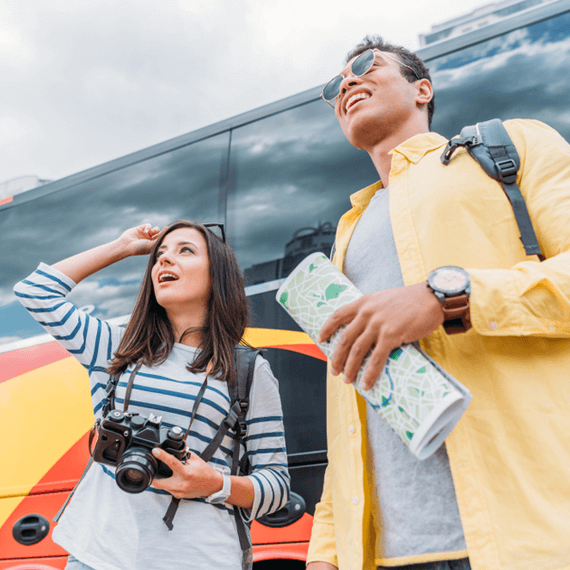 two people in front of a charter bus